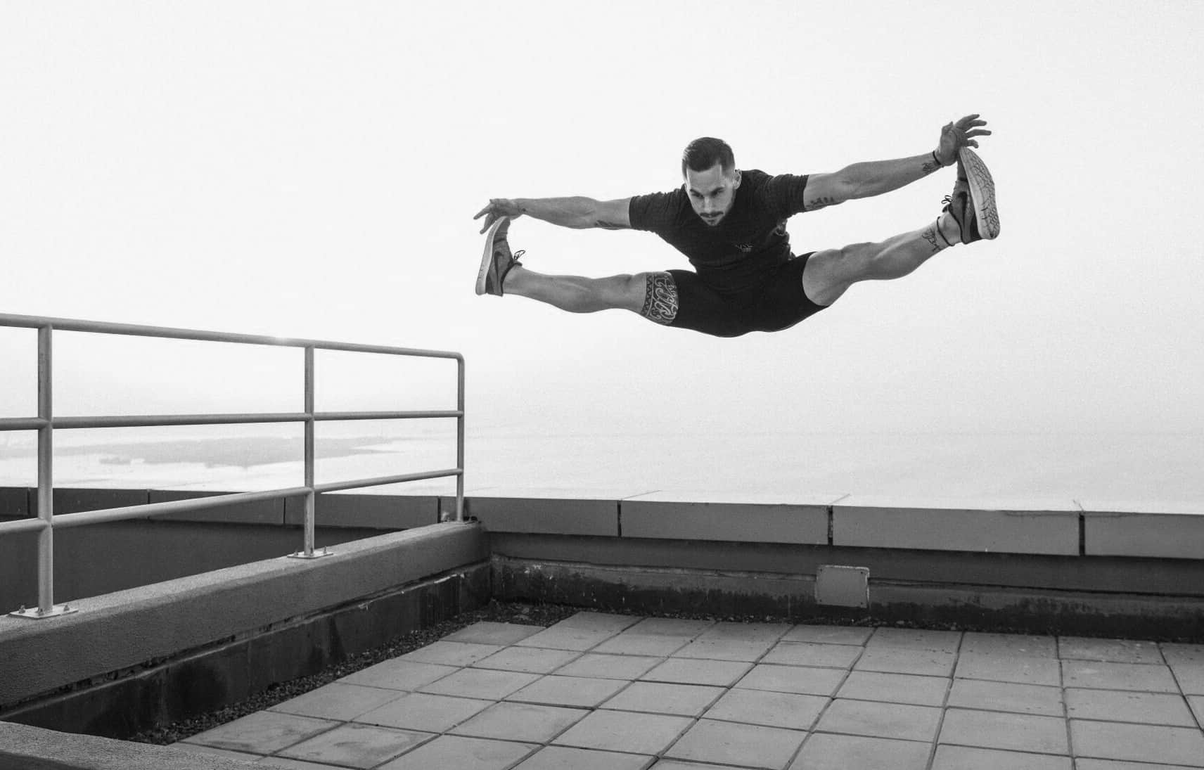 Athlete performing a split jump on a rooftop